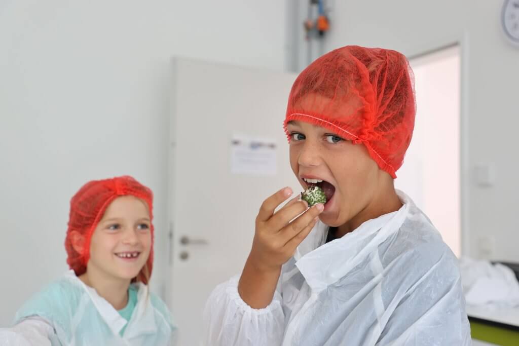 2 Kinder, eines kostet Frischkäse der Käserei WOERLE
