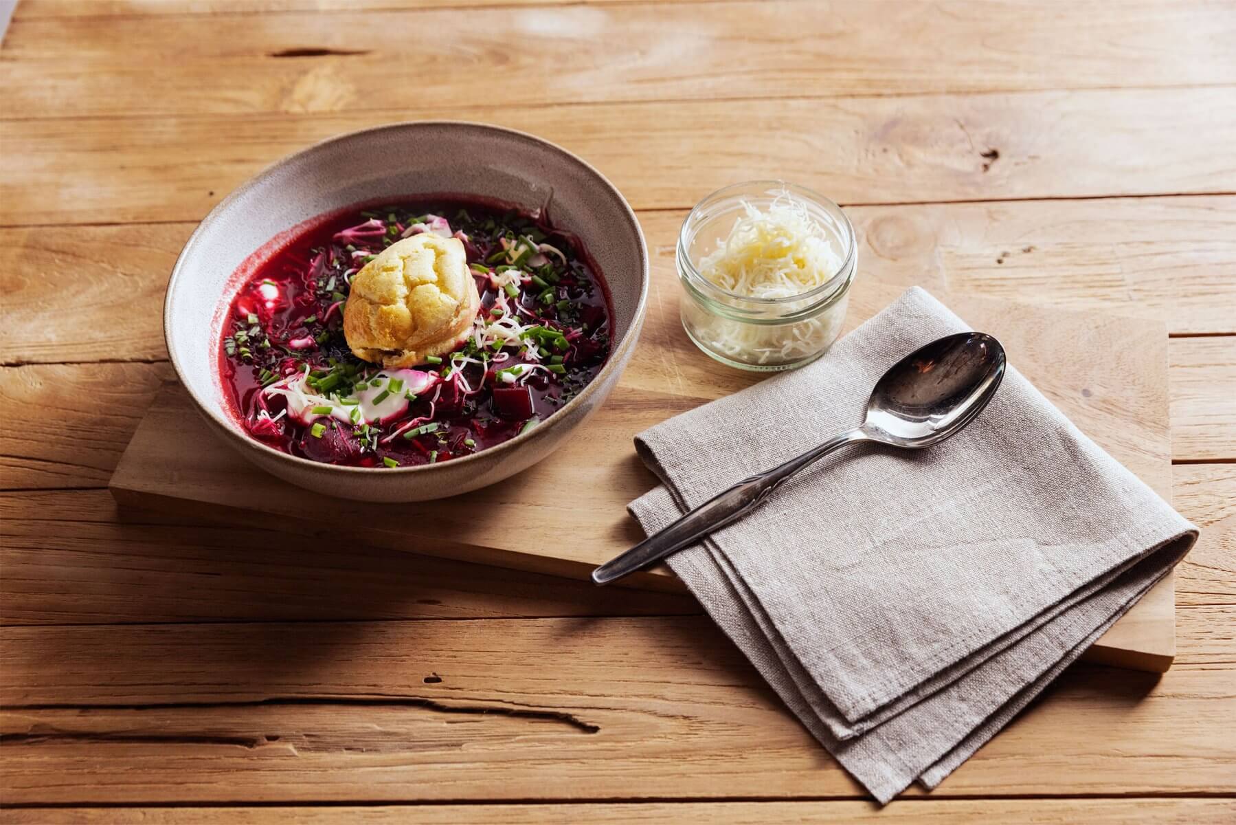 Mondseertörtchen mit Borschtsch in einer Schüssel, daneben eine kleine Schüssel Kren
